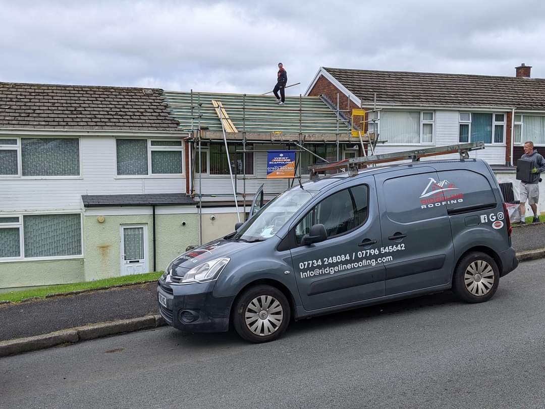 The Ridgeline Roofing van on site with the team working above