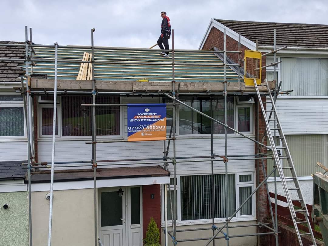 A house mid-strip with scaffolding and the team working on the roof